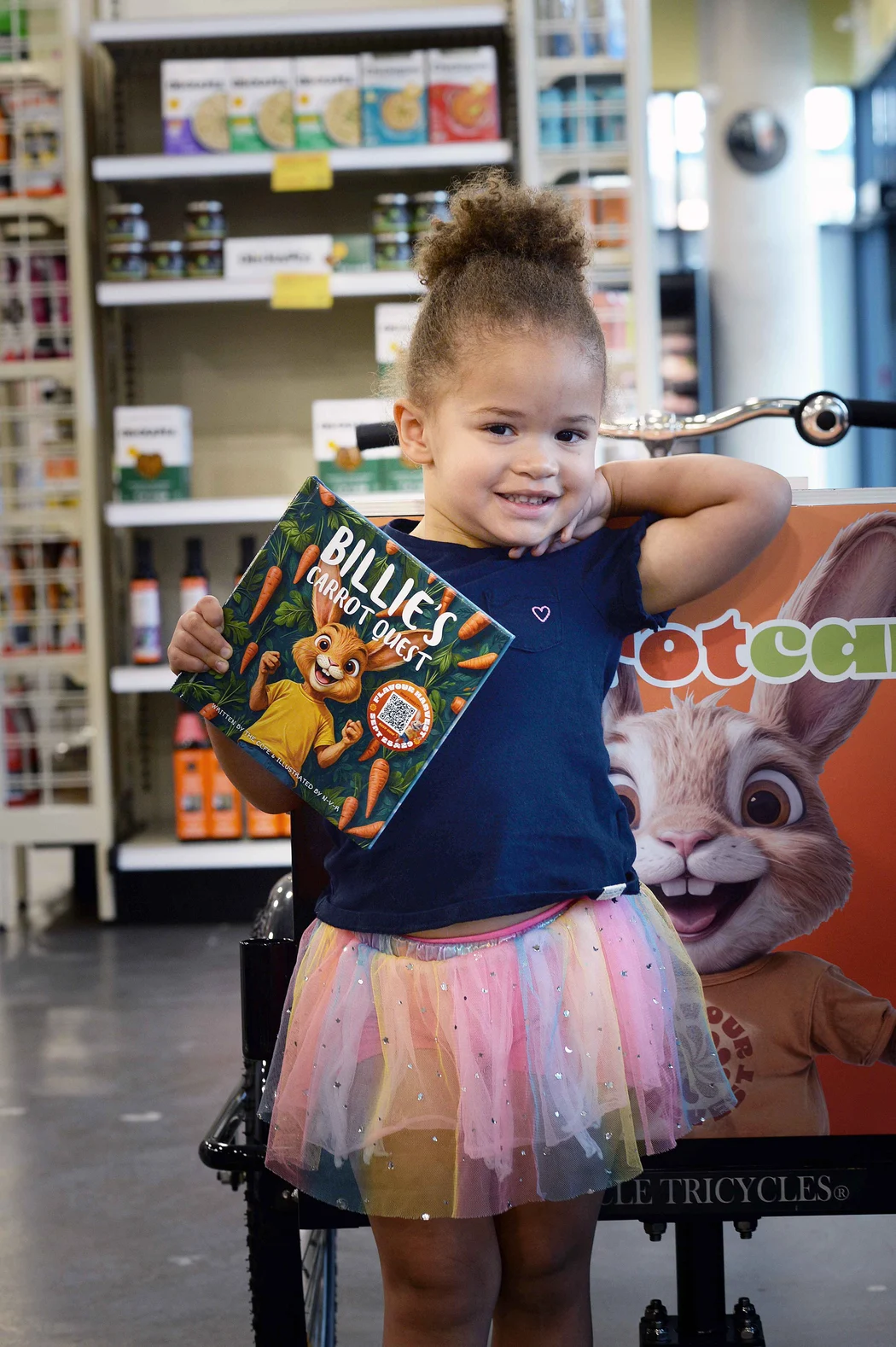 A child proudly holding her own printed copy of Billie’s Carrot Quest.