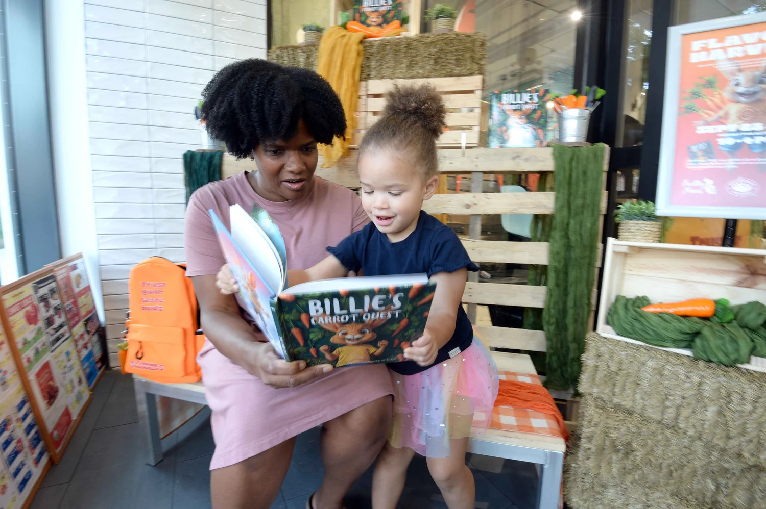 An adult and a young child reading Billie’s Carrot Quest together at the Flavour Harvest event.
