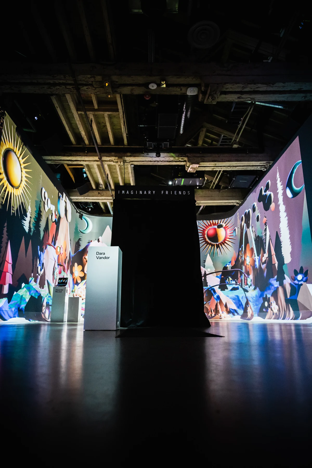 The black-curtained Imaginary Friends photobooth stands beside Dara Vandor’s named plinth inside the immersive exhibition.