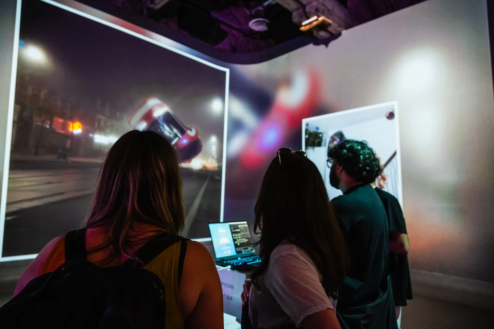 Visitors gather around the Reality Mixer controls while the artwork fills the projection wall.