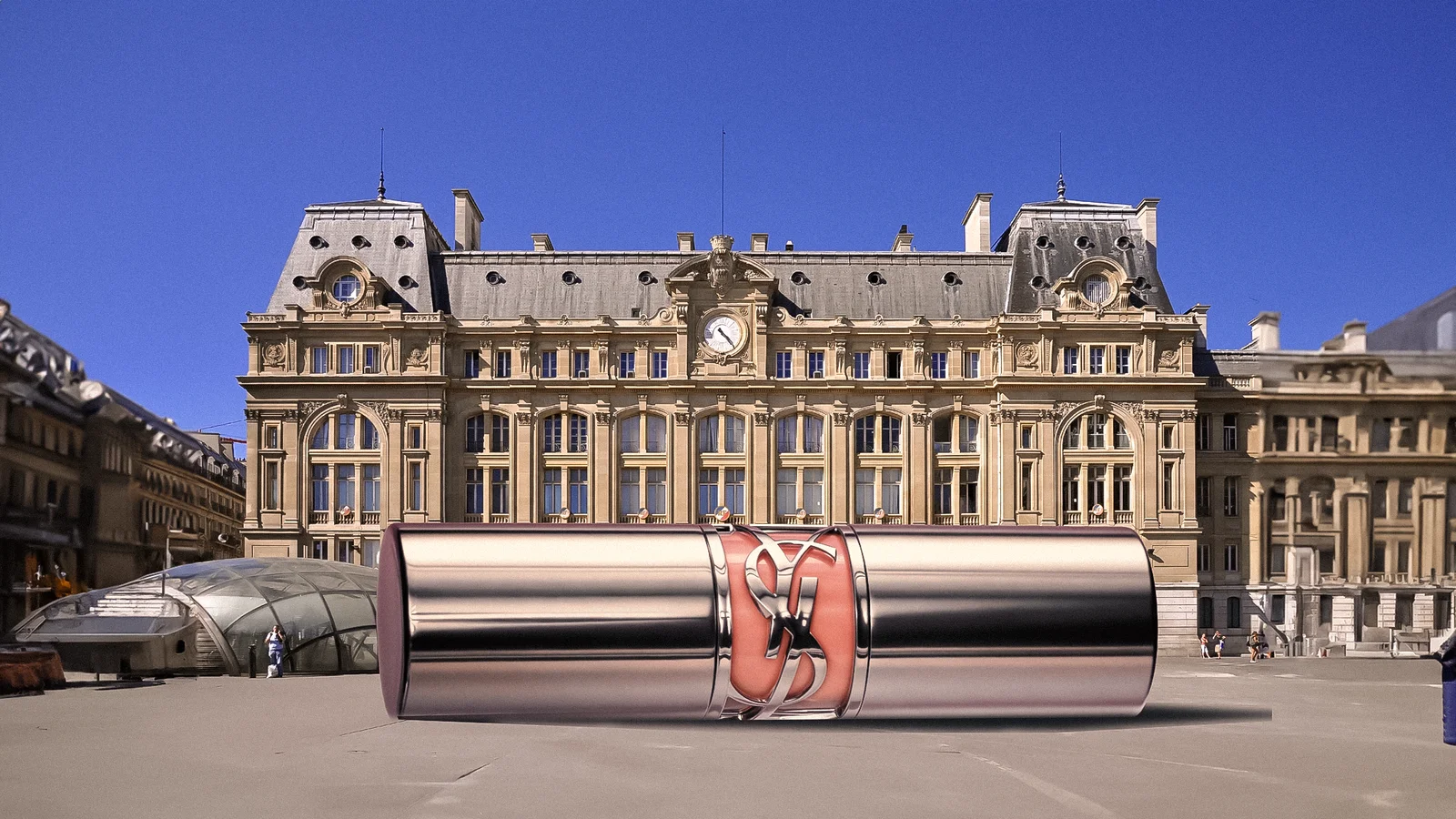 A scene assembly places a giant closed YSL lipstick horizontally in front of Gare Saint-Lazare